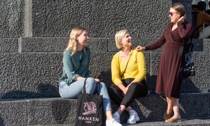 Three women sitting on a statue in Vaasa