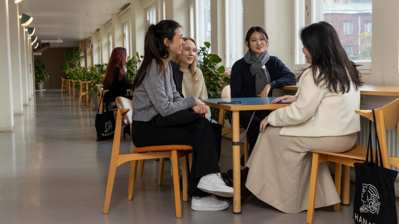 Studenter vid bord i korridoren