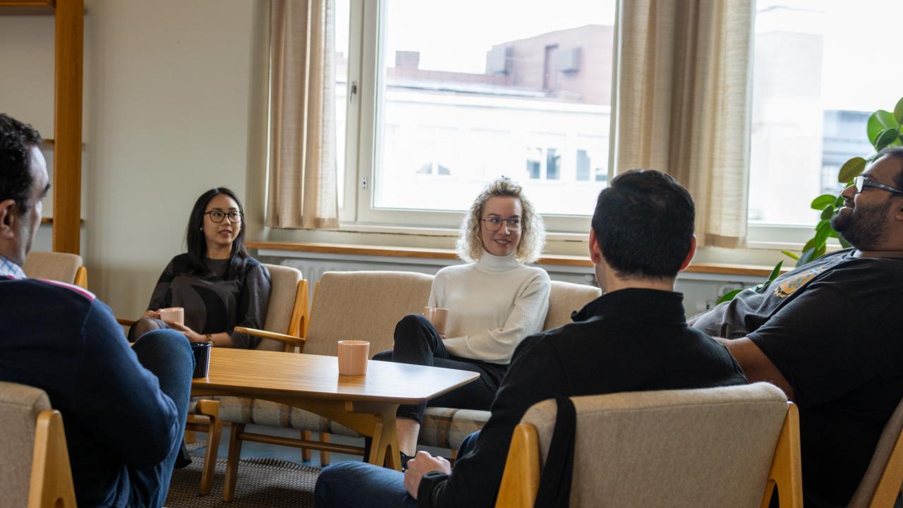 Students sitting aroung table with coffee cups