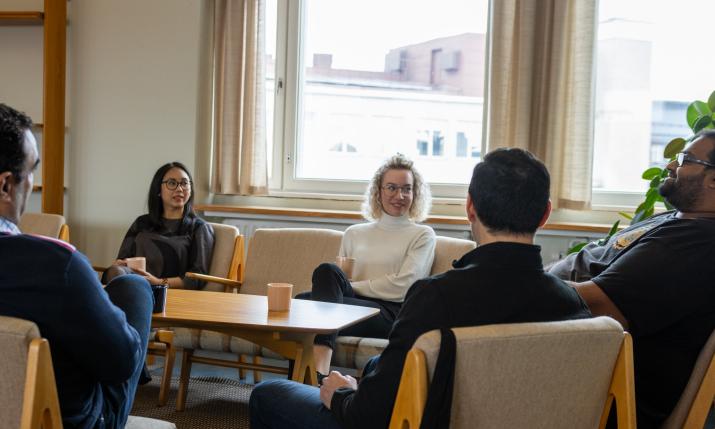 Students sitting aroung table with coffee cups