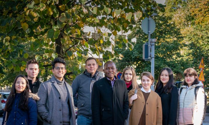 Students standing outside under a tree