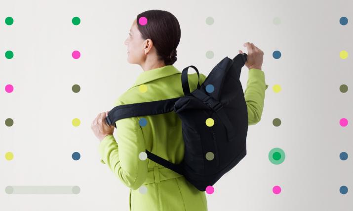 A person photographed from the back wearing a backpack and coat.