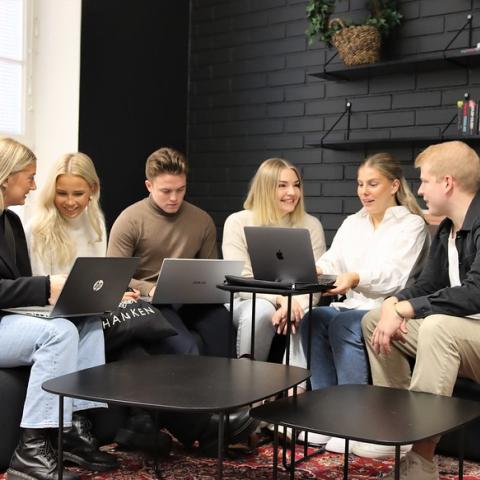 En grupp studenter sitter på en soffa