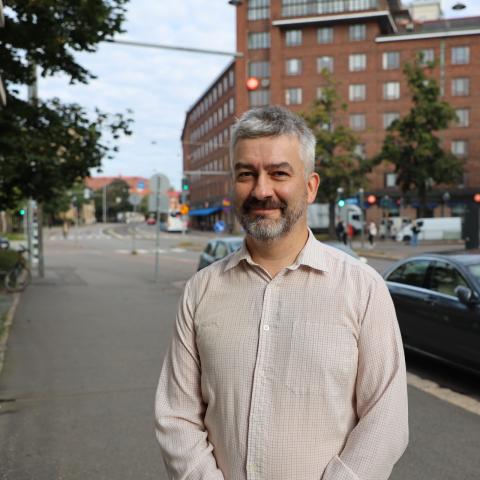 Wojciech Piotrowicz standing in the street outside of Hanken School of Economics.