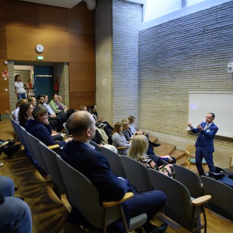 People sitting and listening to a presentation in an auditorium at Hanken