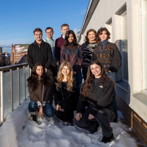 GSM programme students standing on a Hanken balcony in the sun.